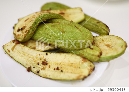 On plate are cooked zucchini with seasoning and garlic On plate are cooked zucchini with seasoning and garlic 69300413