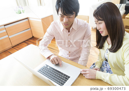 ノートパソコンを見る夫婦 ノートパソコンを見る夫婦 69300473
