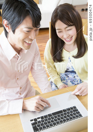 ノートパソコンを見る夫婦 ノートパソコンを見る夫婦 69300474