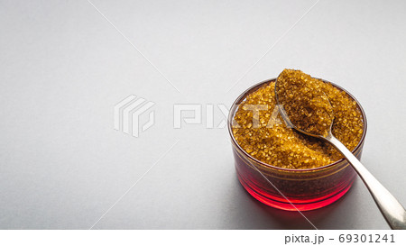Brown sugar with bowl and spoon on background for text Brown sugar with bowl and spoon on background for text 69301241