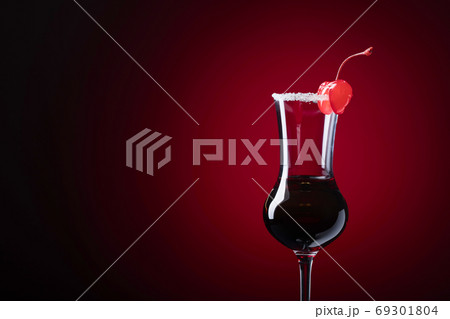 Alcohol shot cocktail garnished with cherry and sugar. 69301804
