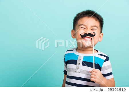 Funny happy hipster kid holding black mustache 69301919