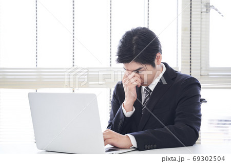 オフィスでノートパソコン操作を失敗する日本人男性ビジネスマン 69302504