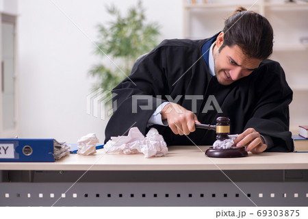Young male judge working in courthouse 69303875