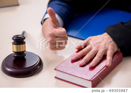 Young male judge working in courthouse 69303887