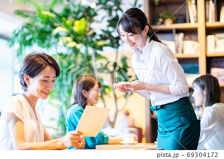 カフェで注文をとる若いスタッフ 69304172