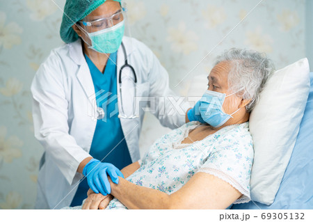 Asian doctor wearing face shield and PPE suit new normal to chec Asian doctor wearing face shield and PPE suit new normal to chec 69305132