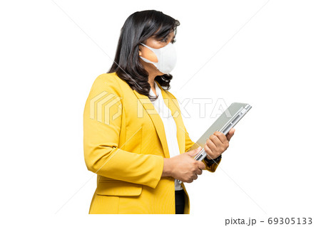 Business asian lady wearing face mask holding laptop isolated on Business asian lady wearing face mask holding laptop isolated on 69305133