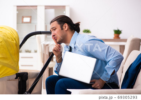 Young businessman looking after newborn at home 69305293