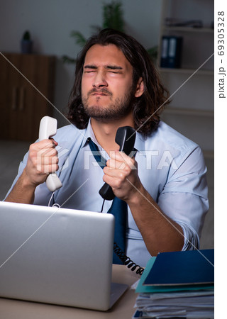 Young businessman working late in the office Young businessman working late in the office 69305328