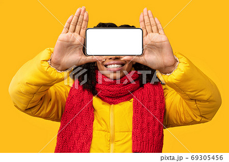 Woman Holding Phone With Empty Screen Near Face, Yellow Background Woman Holding Phone With Empty Screen Near Face, Yellow Background 69305456
