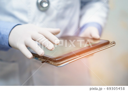 Doctor holding digital tablet to search data for treat patient in nursing hospital ward 69305458