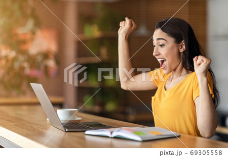 Emotional arab girl got job, shouting in front of laptop Emotional arab girl got job, shouting in front of laptop 69305558