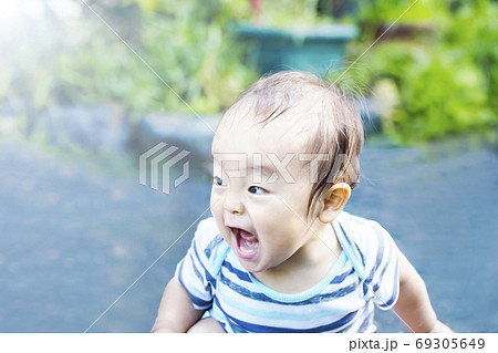 外で大声で叫び大興奮している子供 水遊びしてずぶ濡れの子供 ガオーの写真素材