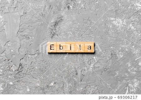 EBITA word written on wood block. EBITA text on cement table for your desing, concept 69306217
