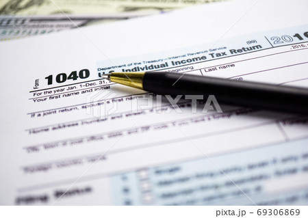Tax Return form 1040 and dollar banknote Tax Return form 1040 and dollar banknote 69306869