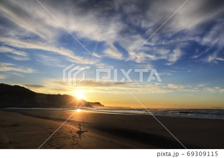 朝日で砂浜と流木が照らされた海岸 69309115