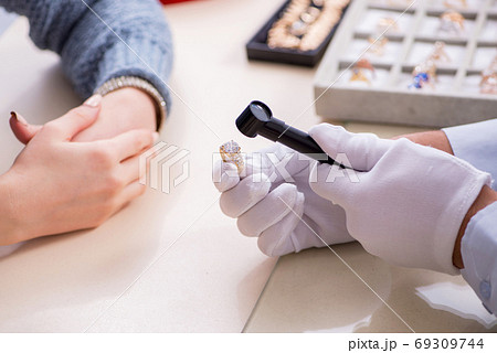 Male jeweler and female client at store 69309744