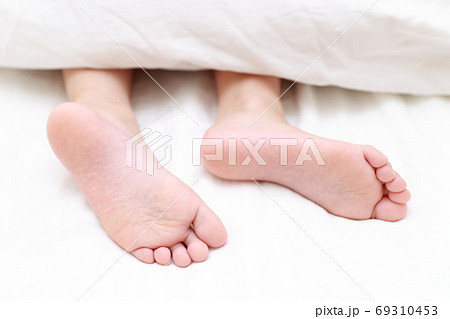 ベッドで眠る女の子の素足 69310453