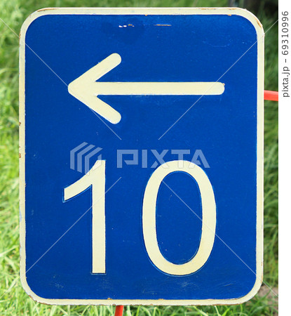 The number ten on a blue metal plate with a white arrow 69310996