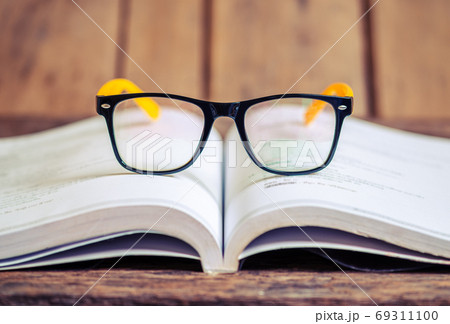 Glasses on the book blurred background 69311100