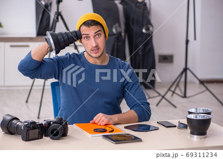 Young male photographer working in the studio Young male photographer working in the studio 69311234