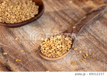 Fenugreek seeds on a wooden spoon 69312257