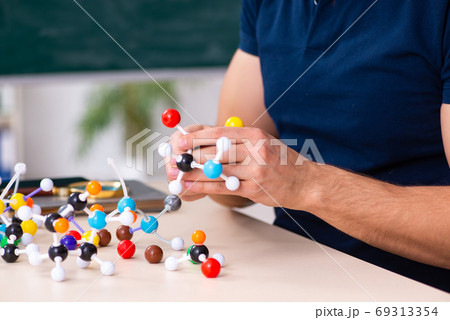 Young male scientist sitting in the classroom Young male scientist sitting in the classroom 69313354