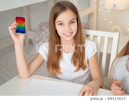 teen girl drawing rainbow. stay at home. 69313637