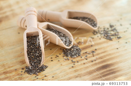 Superfood chia seeds in wooden scoops close-up Superfood chia seeds in wooden scoops close-up 69313753
