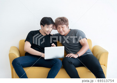 Asian LGBT Gay Couple Using Laptop Computer Together in the Liv Asian LGBT Gay Couple Using Laptop Computer Together in the Liv 69313754