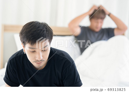 Serious Gay Guy Sitting on the Bed After ..a Serious Quarrel wit 69313825