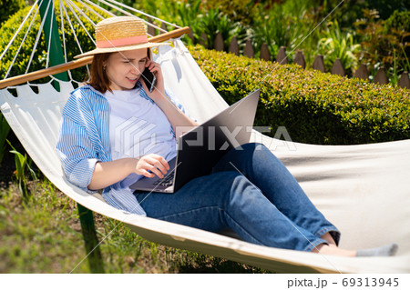 woman lies in hammock and working on computer 69313945