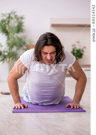 Young male starting day with morning exercises Young male starting day with morning exercises 69314342