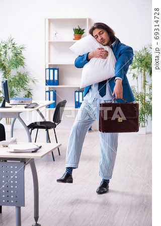 Male employee coming to work straight from bed Male employee coming to work straight from bed 69314728