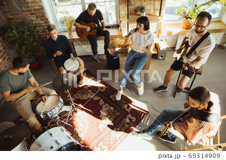 Musician band jamming together in art workplace with instruments Musician band jamming together in art workplace with instruments 69314909