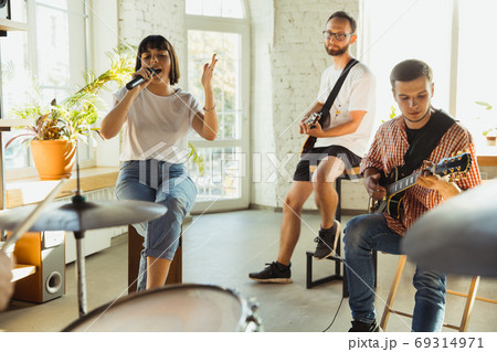 Musician band jamming together in art workplace with instruments Musician band jamming together in art workplace with instruments 69314971