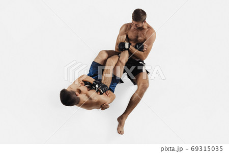 Two professional MMA fighters boxing isolated on white studio background, dynamic and motion. Top view 69315035