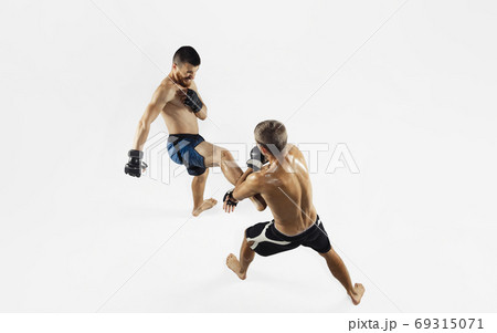 Two professional MMA fighters boxing isolated on white studio background, dynamic and motion. Top view Two professional MMA fighters boxing isolated on white studio background, dynamic and motion. Top view 69315071