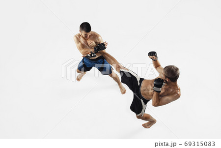 Two professional MMA fighters boxing isolated on white studio background, dynamic and motion. Top view Two professional MMA fighters boxing isolated on white studio background, dynamic and motion. Top view 69315083
