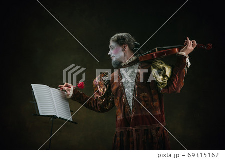 Young man as Johann Sebastian Bach on dark green background. Retro style, comparison of eras concept. Young man as Johann Sebastian Bach on dark green background. Retro style, comparison of eras concept. 69315162