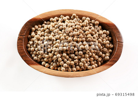 Dried white pepper corns in small wooden bowl - view form above isolated on white background Dried white pepper corns in small wooden bowl - view form above isolated on white background 69315498