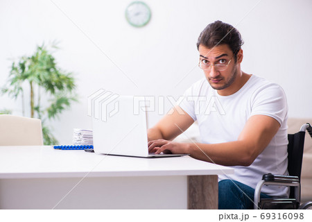 Young disabled man working from house Young disabled man working from house 69316098
