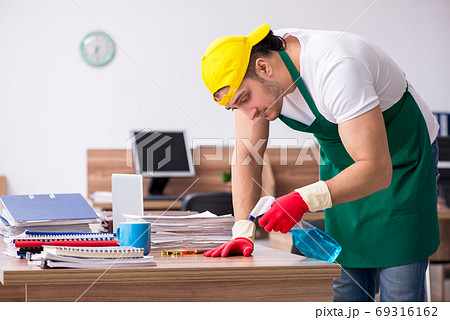 Young male contractor cleaning the office Young male contractor cleaning the office 69316162