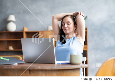 Business woman stretches her body doing yoga exercise at coffee break. 69316695