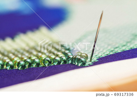 Embroiders with colorful beads. Close-up Embroiders with colorful beads. Close-up 69317336