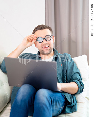 male freak with glasses working online at home. male freak with glasses working online at home. 69317480
