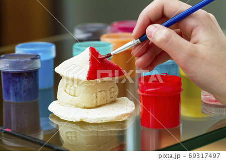 Little girl paints the house from clay or salty Little girl paints the house from clay or salty 69317497