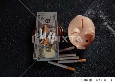 Piggy bank and cigarettes on grey background. Expensive and harmful habit 69318113