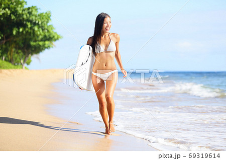 Surfer woman in bikini on beach on Hawaii. Surfboard woman walking in beach water with boogieboard 69319614